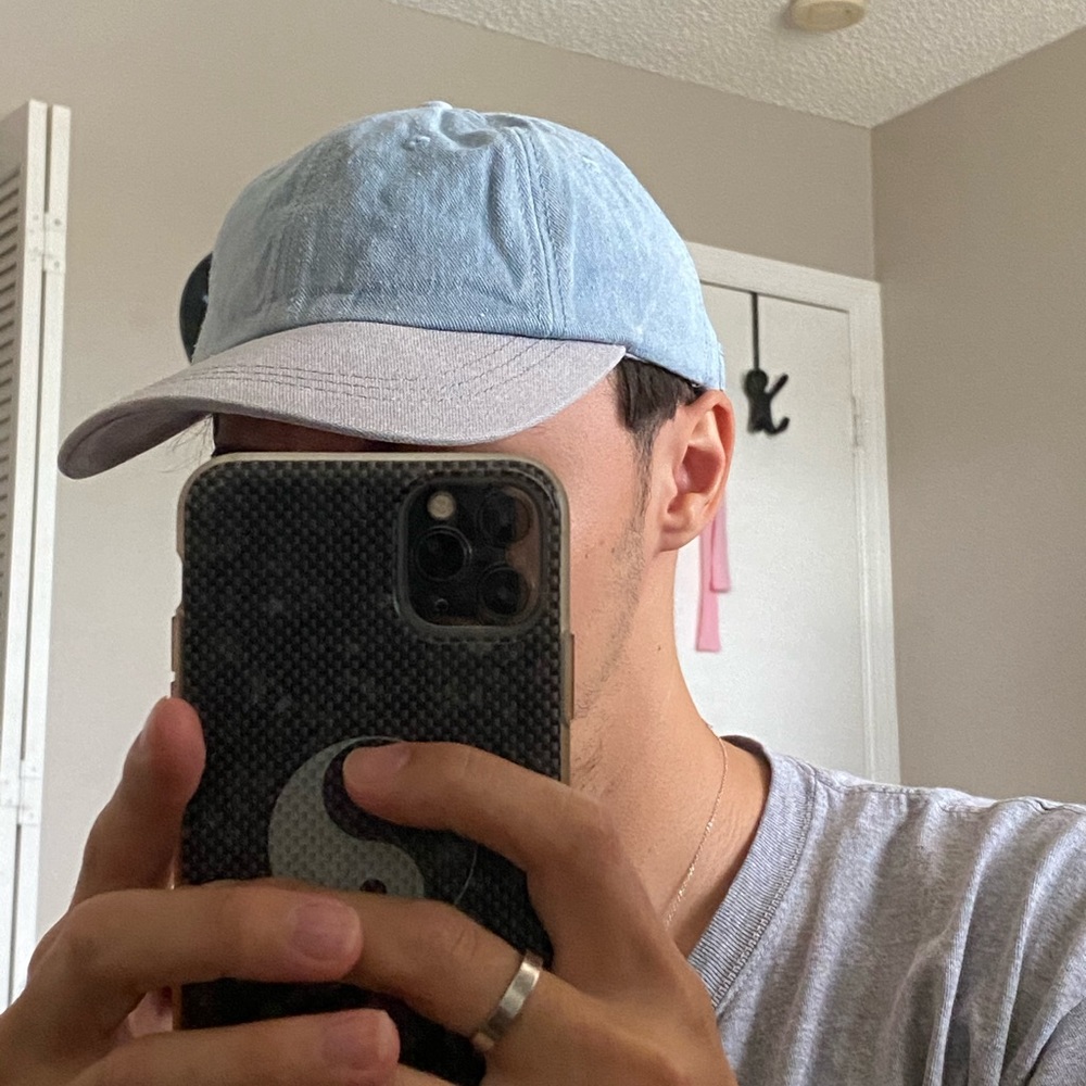 Light wash blue denim and gray baseball hat.